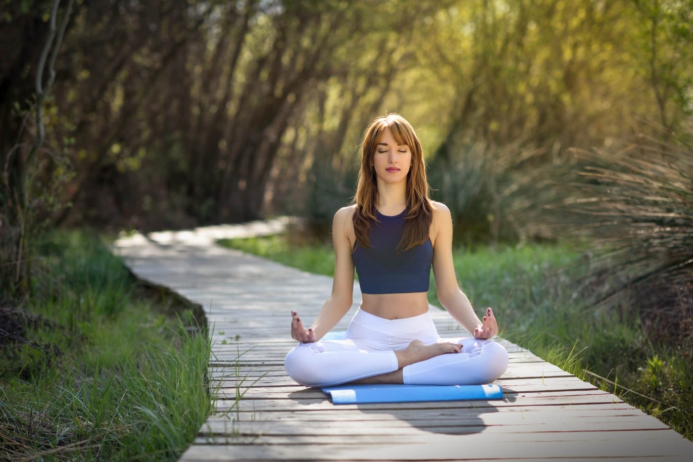 Woman practicing meditation outdoors on a boardwalk in Colorado