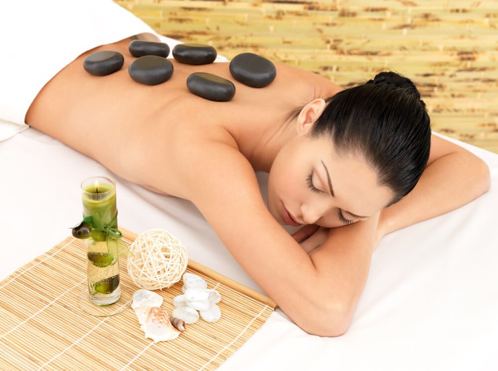 Heated basalt stones placed along a client’s back during a hot stone massage